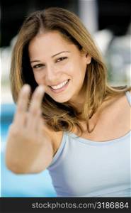 Portrait of a young woman showing a peace sign