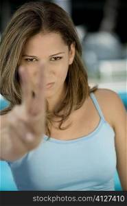 Portrait of a young woman showing a peace sign