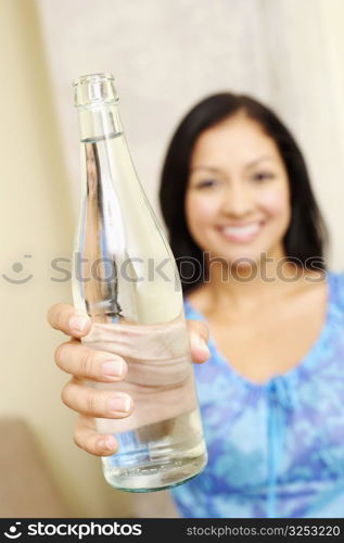 Portrait of a young woman showing a water bottle