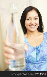 Portrait of a young woman showing a water bottle and smiling