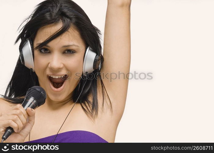 Portrait of a young woman singing into a microphone