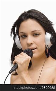 Portrait of a young woman singing into a microphone