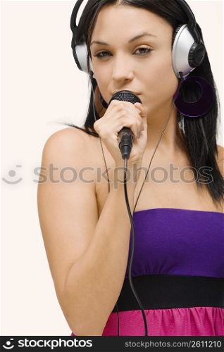 Portrait of a young woman singing into a microphone