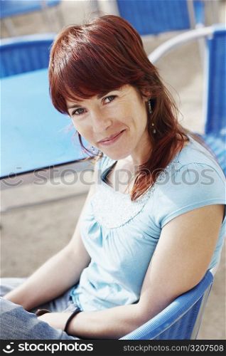 Portrait of a young woman sitting at a sidewalk cafe