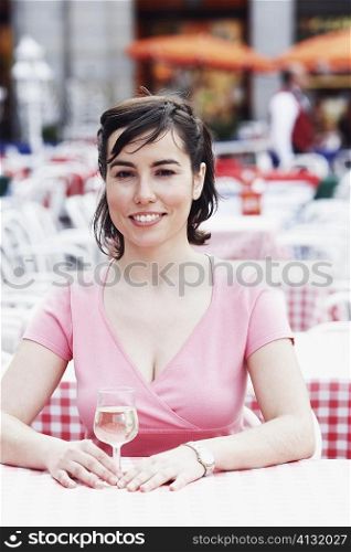 Portrait of a young woman sitting at a table in a sidewalk cafe