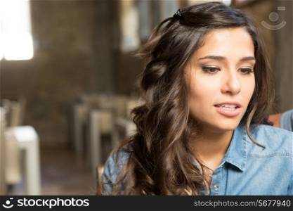Portrait of a young woman sitting at cafe table