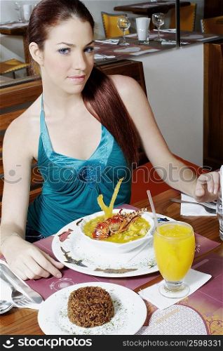 Portrait of a young woman sitting at the dining table