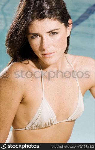 Portrait of a young woman sitting at the poolside