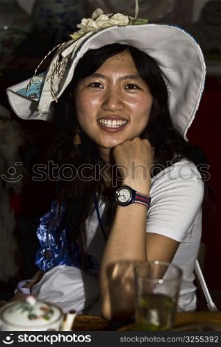 Portrait of a young woman sitting in a cafe and smiling, Xidi, Anhui Province, China