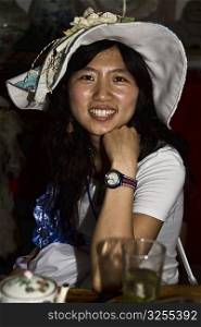 Portrait of a young woman sitting in a cafe and smiling, Xidi, Anhui Province, China