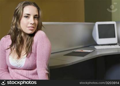 Portrait of a young woman sitting in a computer lab
