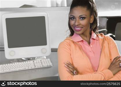 Portrait of a young woman sitting in a computer lab and smiling