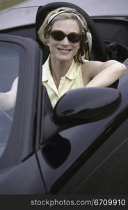 Portrait of a young woman sitting in a convertible car