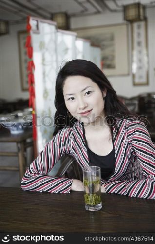 Portrait of a young woman sitting in a restaurant smiling