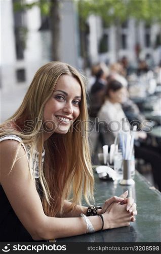 Portrait of a young woman sitting in a sidewalk cafe