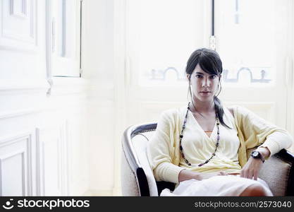 Portrait of a young woman sitting in an armchair