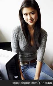 Portrait of a young woman sitting in front of a computer