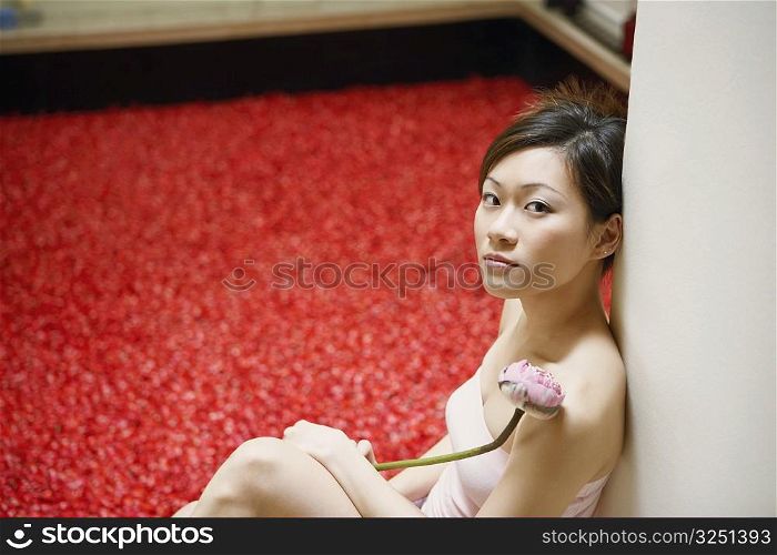 Portrait of a young woman sitting near a hot tub and thinking