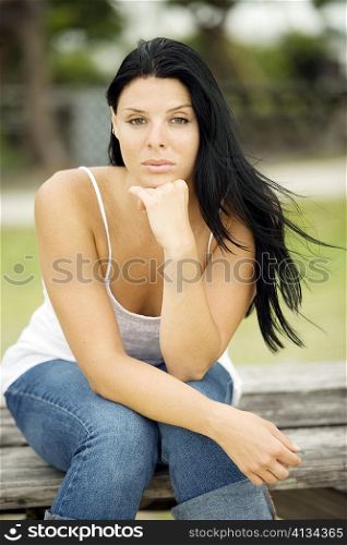 Portrait of a young woman sitting on a bench