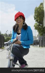 Portrait of a young woman sitting on a bicycle and smiling