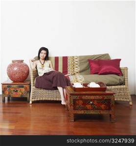 Portrait of a young woman sitting on a couch