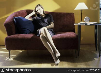 Portrait of a young woman sitting on a couch