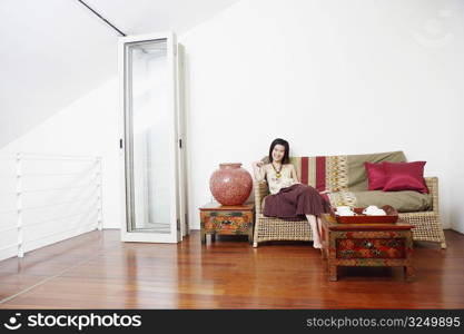 Portrait of a young woman sitting on a couch and smiling