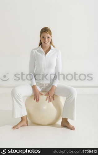 Portrait of a young woman sitting on a fitness ball