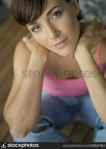 Portrait of a young woman sitting on a hardwood floor