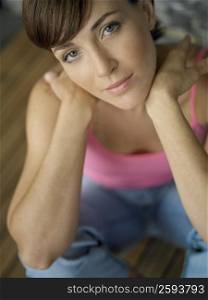 Portrait of a young woman sitting on a hardwood floor