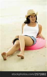 Portrait of a young woman sitting on an inflatable ring