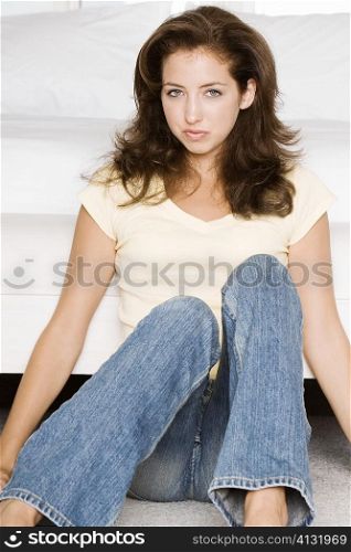 Portrait of a young woman sitting on the floor