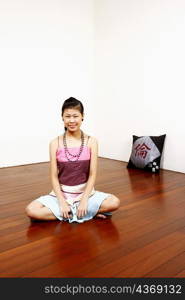 Portrait of a young woman sitting on the floor and smiling