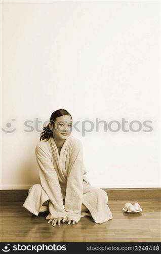 Portrait of a young woman sitting on the floor with a plate of soap