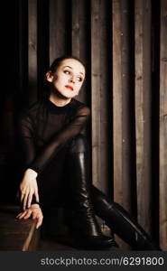 Portrait of a young woman sitting on wooden stairs