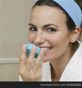 Portrait of a young woman smelling a bar of soap