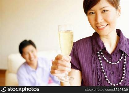 Portrait of a young woman smiling and holding a champagne flute