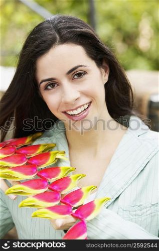 Portrait of a young woman smiling and holding flowers