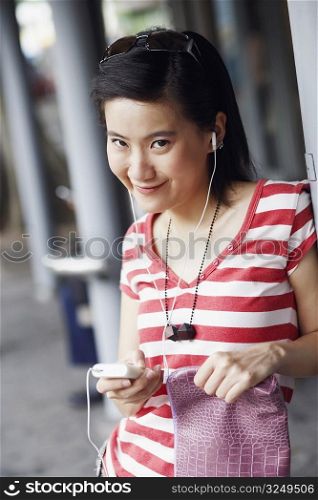 Portrait of a young woman smiling and listening to music