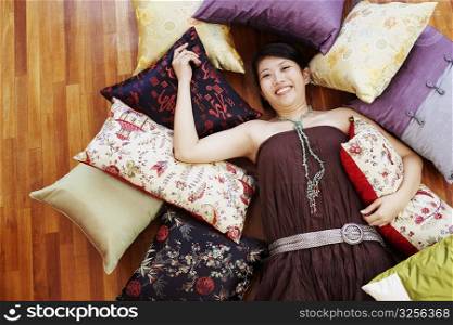 Portrait of a young woman smiling and lying on a hardwood floor