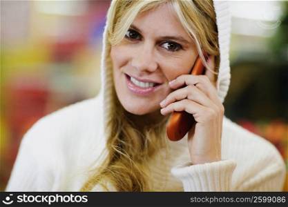 Portrait of a young woman smiling and talking on a mobile phone