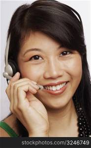 Portrait of a young woman smiling and wearing a headset