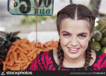 Portrait of a young woman smiling at a market stall