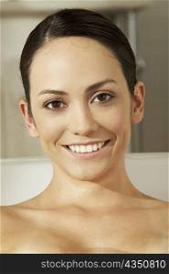 Portrait of a young woman smiling in a bathtub