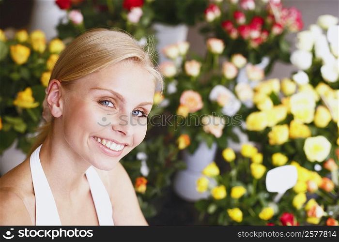 Portrait of a young woman smiling in a flower shop