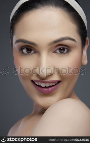 Portrait of a young woman smiling over colored background