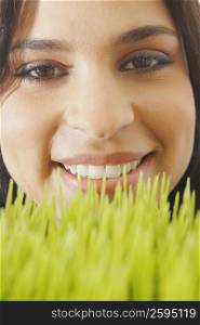 Portrait of a young woman smiling over wheatgrass