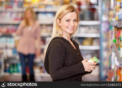 Portrait of a young woman smiling while shopping in the supermarket