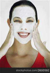 Portrait of a young woman smiling with a facial mask on her face