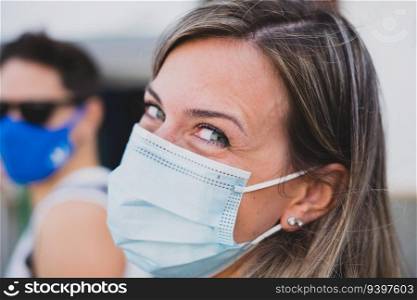 Portrait of a young woman smiling with a surgical face mask